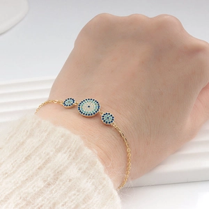 Elegant gold S925 sterling silver evil eye bracelet with blue crystals on model wrist
