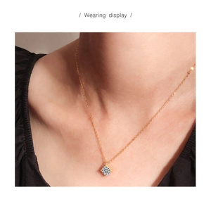 Wearing display of a delicate gold S925 sterling silver necklace with a sparkling solitaire diamond