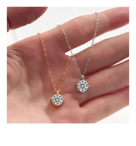 Close-up of gold and silver S925 necklaces with round brilliant-cut four-prong pendants