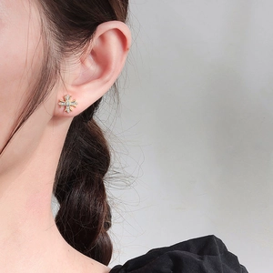 Boucles d'oreilles clous croix en argent 925 avec cristaux portées par un mannequin