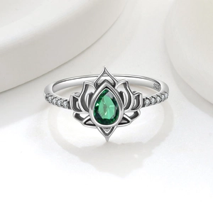 Dettaglio macro anello loto in argento S925 con zircone verde a goccia e pietre bianche laterali