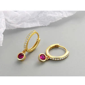 Gros plan de boucles d'oreilles créoles en argent S925 doré avec pierre rouge et cristaux