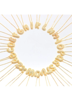 Macro shot of 26 bubbly gold alphabet pendants with paved cubic zirconia stones