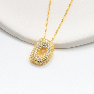 Macro shot of 925 silver golden puffy letter D pendant with glittering cubic zirconia