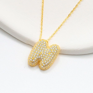 Detailed macro view of S925 silver bubble letter M pendant with sparkling cubic zirconia stones