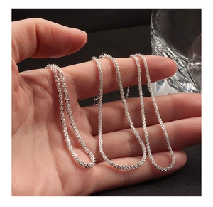 Detail of s925 sterling silver chain featuring faceted texture and S-hook clasp on hand