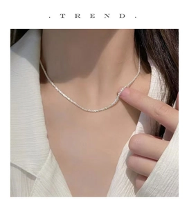 Close-up of minimalist S925 sterling silver water ripple necklace worn on neck
