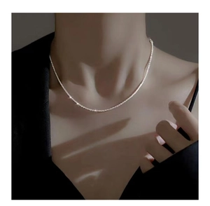 Macro detail of shimmering S925 sterling silver chain necklace on female neck