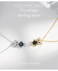 Detailed view of sterling silver bear pendants with blue crystals and pavé diamonds