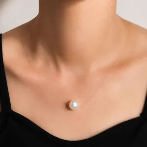 Close-up of a single lustrous pearl on a transparent invisible fishing line necklace