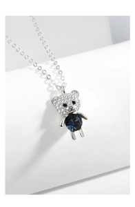 Macro detail of silver bear necklace with deep blue crystal and sparkling pave accents