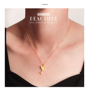 Detail van een gouden hart sleutel hanger ketting met kristallen op een model