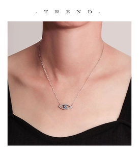 Close-up of S925 sterling silver evil eye necklace with blue rhinestones on a model