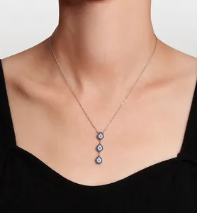 Dettaglio collana in argento S925 con tre ciondoli in cristallo blu indossata su collo
