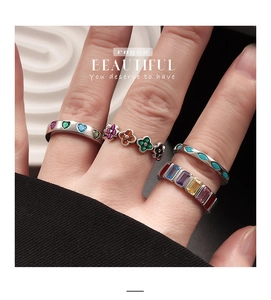 Detailed view of stacked S925 silver rings with colorful heart and clover gemstones