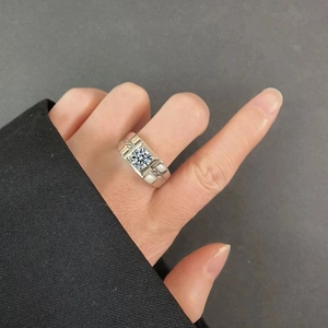 Macro shot of men's wide silver moissanite ring with side stones on hand