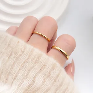 Detalle macro de anillos dorados minimalistas apilados con acabado pulido espejo