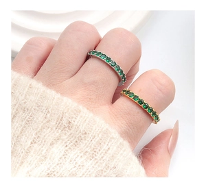 Nahaufnahme von Eternity-Ringen mit smaragdgrünen Steinen in Silber und Gold