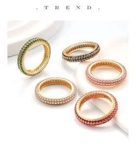 Macro detail of luxury gold-plated silver rings with colorful pave zircon settings