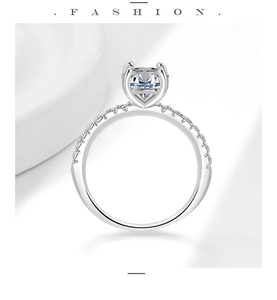 Macro shot of oval-cut solitaire moissanite ring with paved diamonds in 925 silver