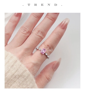 Close-up of S925 silver ring featuring pink emerald cut stone and marquise side diamonds