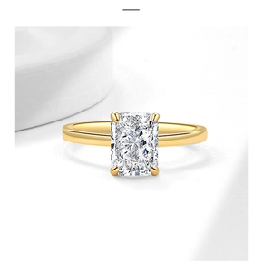 Dettaglio anello dorato con zircone taglio radiant e incastonatura a quattro griffe