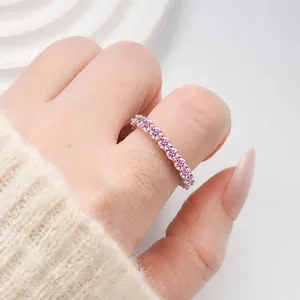 Close-up of eternity band ring with pink stones set in a silver-colored setting