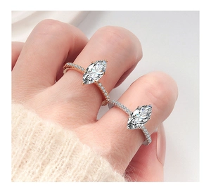 Dettaglio di anelli marquise in oro rosa e argento con pavé indossati sulla mano