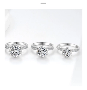 Dettaglio di tre anelli moissanite in argento S925 con castone floreale a sei griffe