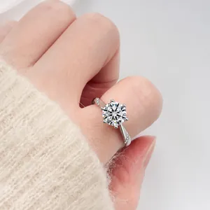 Gros plan d'une bague en argent 925 à six griffes avec anneau torsadé sur la main