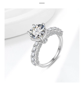 Detailed close-up of S925 silver stamp on a six-prong solitaire ring with side diamonds
