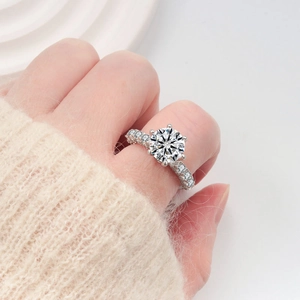 Luxurious S925 silver six-prong moissanite ring worn on hand with knit sweater background