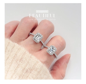 Close-up of S925 sterling silver rings featuring emerald cut and halo moissanite stones