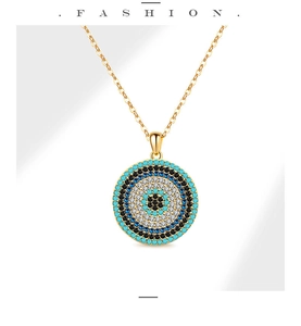 Détail du pendentif œil protecteur doré avec incrustation de turquoise et pierres bleues