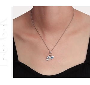 Détail du collier S925 en argent avec pendentifs Hamsa et mauvais œil sur le cou