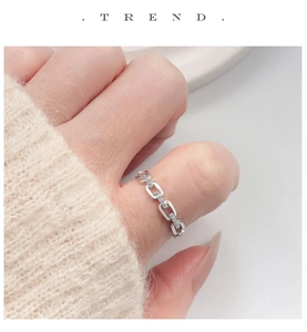 Macro shot of silver chain link ring with sparkling cubic zirconia on index finger