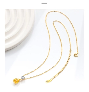 Close-up of S925 sterling silver gold chain with yellow pear-cut gemstone pendant