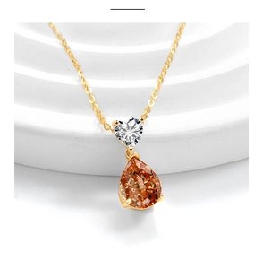 Detail of S925 silver necklace with heart-shaped zircon and orange teardrop stone