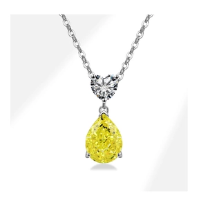 Detailed view of silver necklace with heart-shaped stone and yellow pear-cut pendant
