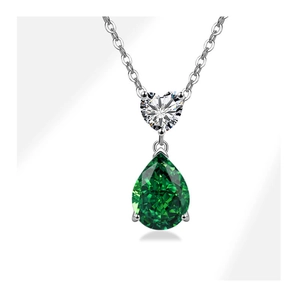 Macro view of S925 silver necklace with heart-shaped stone and green teardrop pendant
