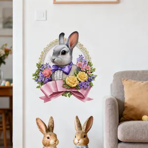 Osterwandaufkleber mit grauem Hasen, Blumen und rosa Schleife auf einer weißen Wand