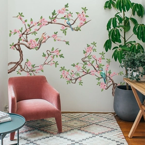 Detalle de vinilos decorativos de ramas de flores rosas y pájaros en un salón minimalista