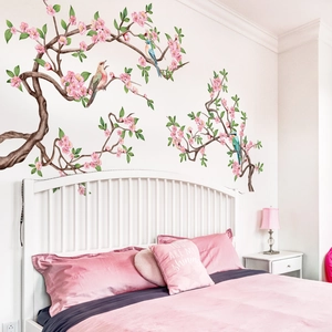 Vinilos decorativos de ramas de cerezo rosa y pájaros en una habitación acogedora