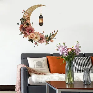 Detail of floral wall sticker with golden crescent moon and vintage lantern on a white wall