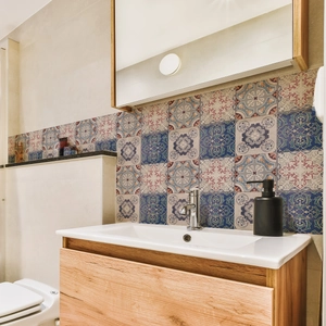 Detail of vintage mandala tile stickers on a bathroom backsplash with wooden vanity