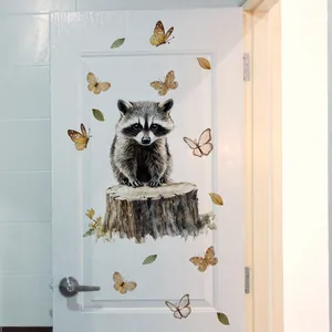 Detail of hand-painted raccoon and butterfly wall sticker on a white wooden door decor