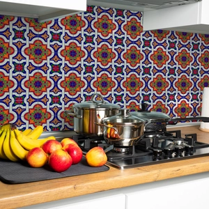Close-up of colorful Mediterranean geometric pattern wall tiles behind a kitchen stove