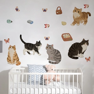 Detail of cartoon cat wall decals with butterflies in a cozy baby nursery room setting
