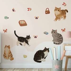 Detailed view of hand-painted cat and butterfly wall stickers in a cozy bedroom