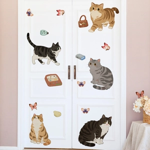 Detail of cartoon cat and butterfly wall stickers applied on a white bedroom door